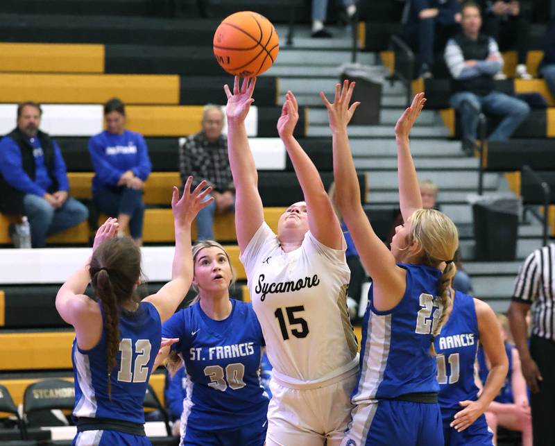 Sycamore's Sophia Klacik shoots between three St. Francis defenders during their game Thursday, Jan. 4, 2023, at Sycamore High School.