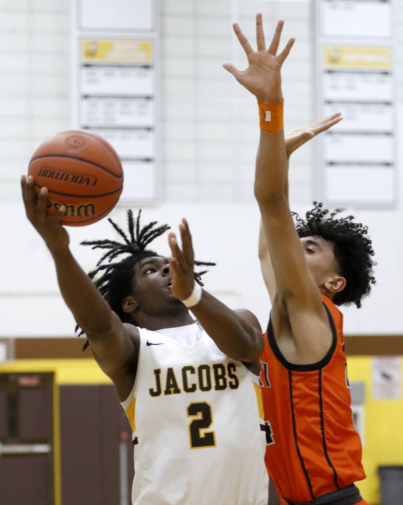 Jacobs' Treval Howard drives to the basket against McHenry's Adam Anwar during a Fox Valley Conference boys basketball game on Wednesday, Nov. 29, 2023, at Jacobs High School in Algonquin.