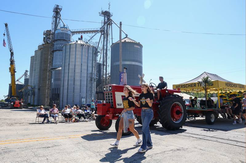 Gianna High, right, and Sophie Venckauskas, teammates in soccer and cross country, walk with fellow Herscher High School athletes down Main Street passing out candy during the 104th annual Herscher Labor Day Celebration Grand Parade on Monday, Sept. 1, 2025.