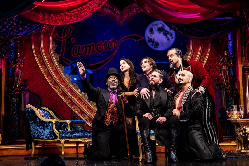 In Broadway in Chicago's North American Tour of "Moulin Rouge! The Musical," the Duke of Monroth (David Harris, front row, center) is pitched an idea for a new show. Those attempting to persuade him include, from left to right, Toulouse Lautrec (Andre Ward), Satine (Courtney Reed), Christian (Conor Ryan), Harold Zidler (Austin Durant) and Santiago (Gabe Martinez). "Moulin Rouge" runs through Sat., May 14 at the James M. Nederlander Theatre, 24 W. Randolph St., Chicago.