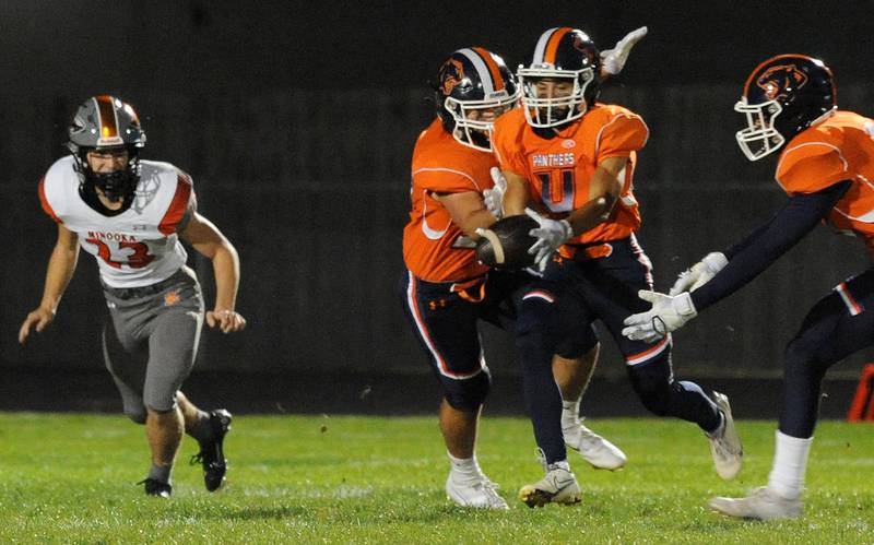 Oswego's Triston August (4) scoops up a blocked punt and gets past Minooka kicker Bradon McCabe (23) to score a special teams touchdown during a varsity football game at Oswego High School on Friday.