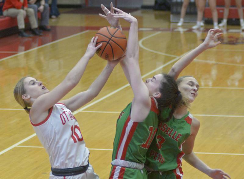 Ottawa’s Ella Schmitz and the Cavalier’s Bailey Pode and Kaylee Abens fight for a rebound Thursday during the 1st period at Ottawa.