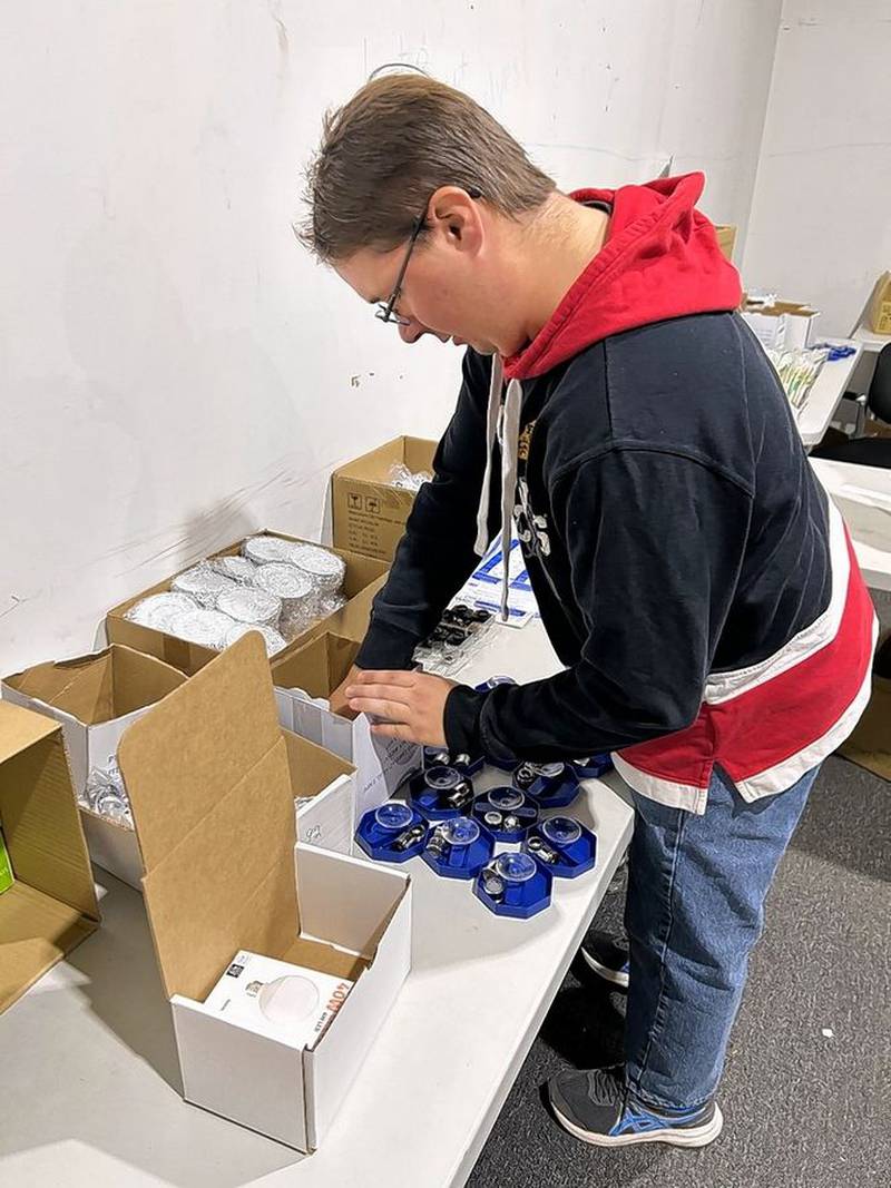 Mike Mackowiak, a fulfillment associate with energy efficiency service company Green Home Experts based in Lyons, packs kits with shower timers to help consumers take shorter showers.