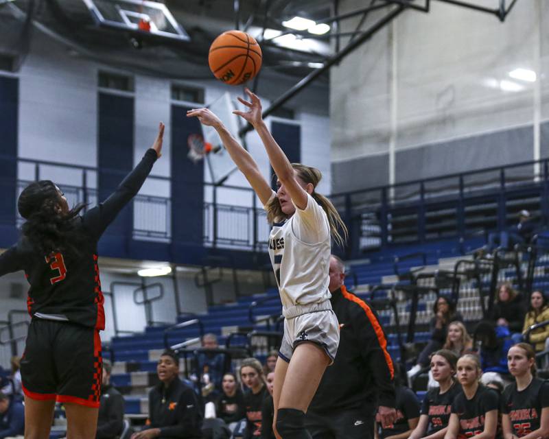 Oswego East's Nicole Warbinski (12) shoots a three pointer during their basketball game between Minooka at Oswego East Friday, Jan 16, 2026 in Oswego.
