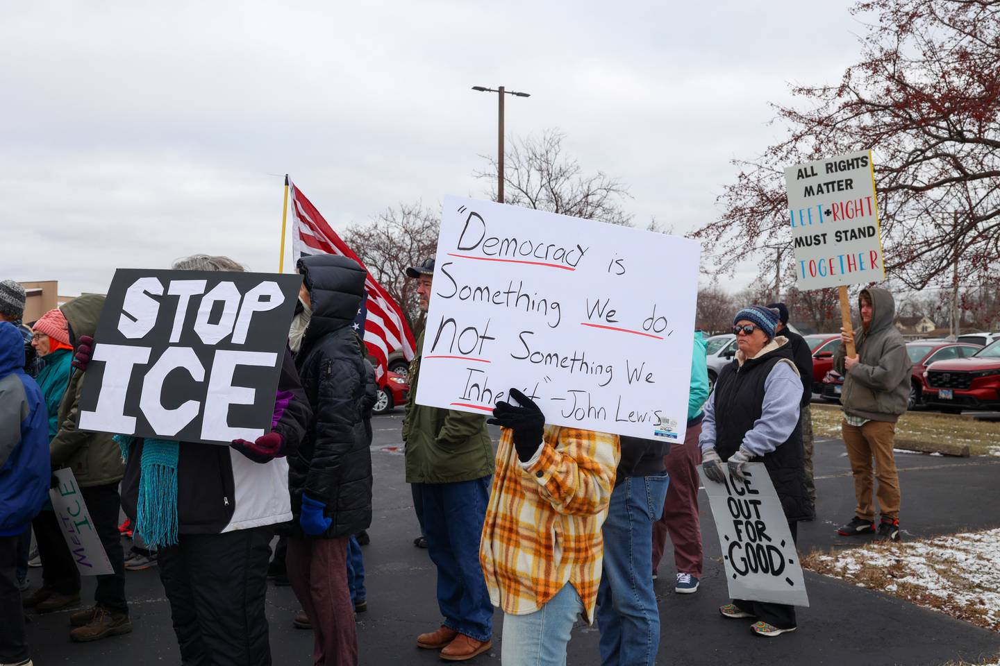 Attendees hold signs during an ICE Out for Good protest and vigil at The Grow Center in Bourbonnais on Sunday, Jan. 11, 2026.