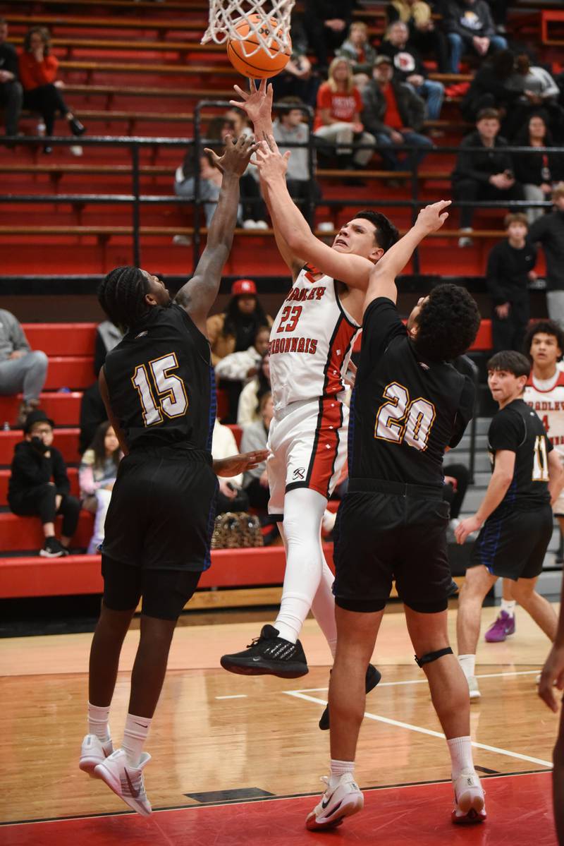 Bradley-Bourbonnais' Julian Gonzalez, center, takes a shot between Sandburg's Kendall McDowell, left, and Karim Diab during a game at Bradley-Bourbonnais Tuesday, Feb. 3, 2026.