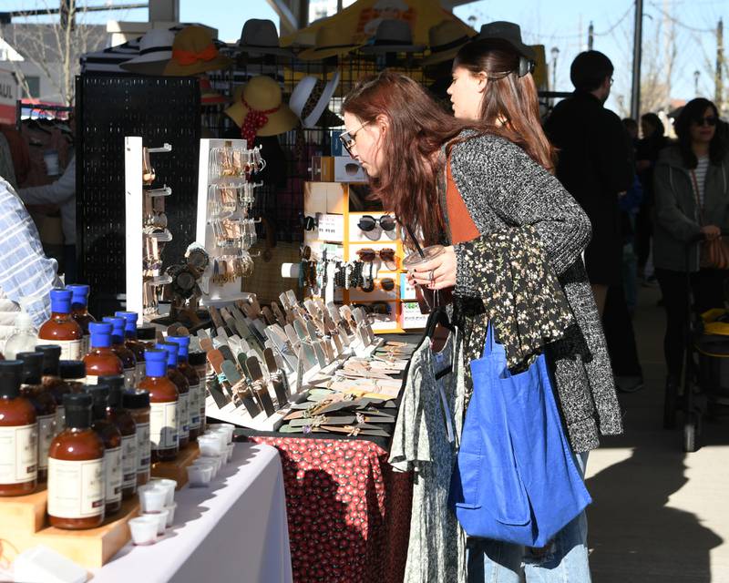 Patience lewis of Lisle looks at some jewelry during the Wheaton French Market on Saturday April 13, 2024, in downtown Wheaton.