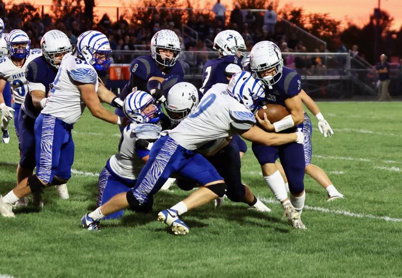 Princeton's Arthur Burden puts a hit on Monmouth-Roseville quarterback Andy Myers Friday at Monmouth. The Titans upset the Tigers 31-3.