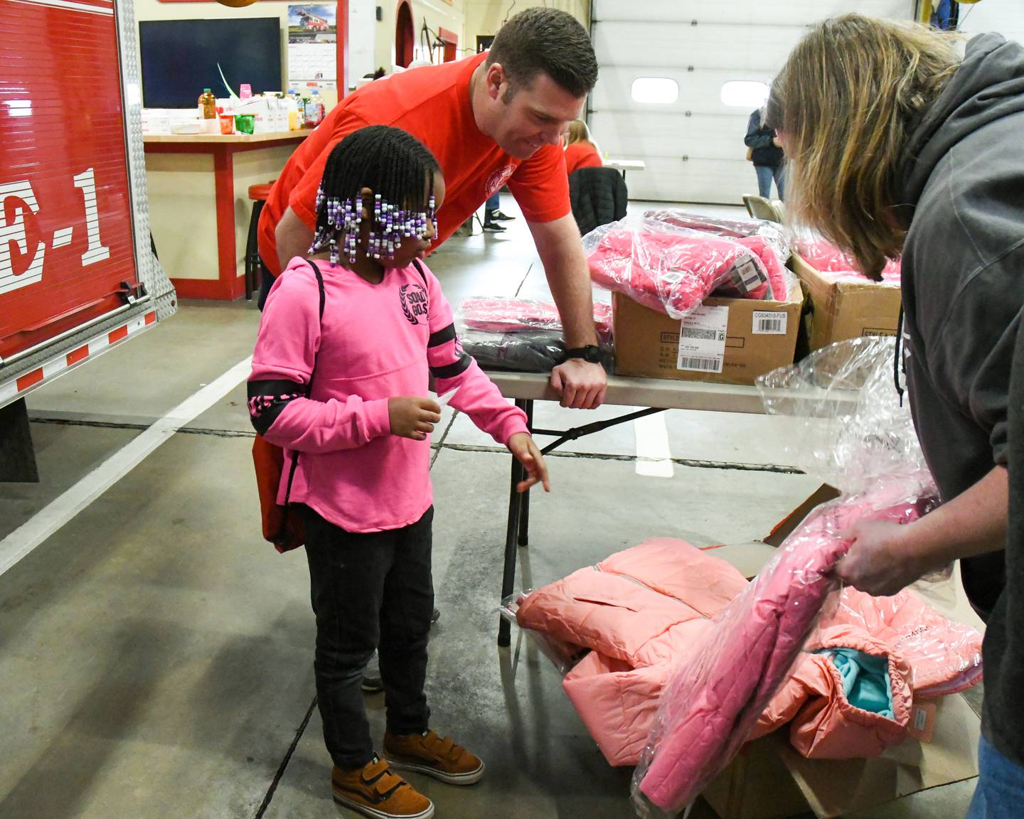 Shaw Local 2019 file photo – Armani Williams, of DeKalb, picks out a jacket during Operation Warm with the help of the late Amy Fontana (right) along with firefighter/paramedic DeKalb Noah Millard on Nov. 23, 2019, at Fire Station No. 1 on Pine Street.