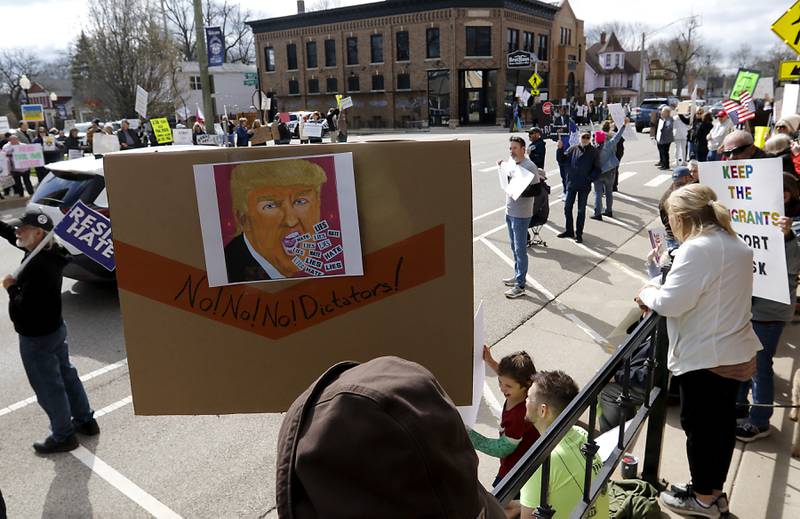 Protesters line U.S. Route 12 in Richmond to protest their discontent with President Donald Trump and his administration's policies on Saturday, April 19, 2025. Over 100, people took part in the Richmond protest. A second rally was held in Harvard later in the day.