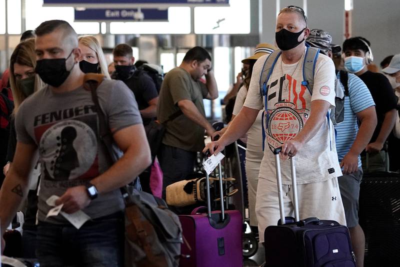 FILE - Travelers are lining up at O'Hare airport in Chicago, Friday, July 2, 2021.  The federal requirement to wear face masks on airplanes and public transportation is scheduled to expire next week, and airline executives and Republican lawmakers are urging the Biden administration to let the mandate die. The fate of the rule — and consideration of an alternate “framework” of moves to limit the spread of COVID-19 — was under discussion Monday, April 11, 2022 within the U.S. Centers for Disease Control. (AP Photo/Nam Y. Huh, File)