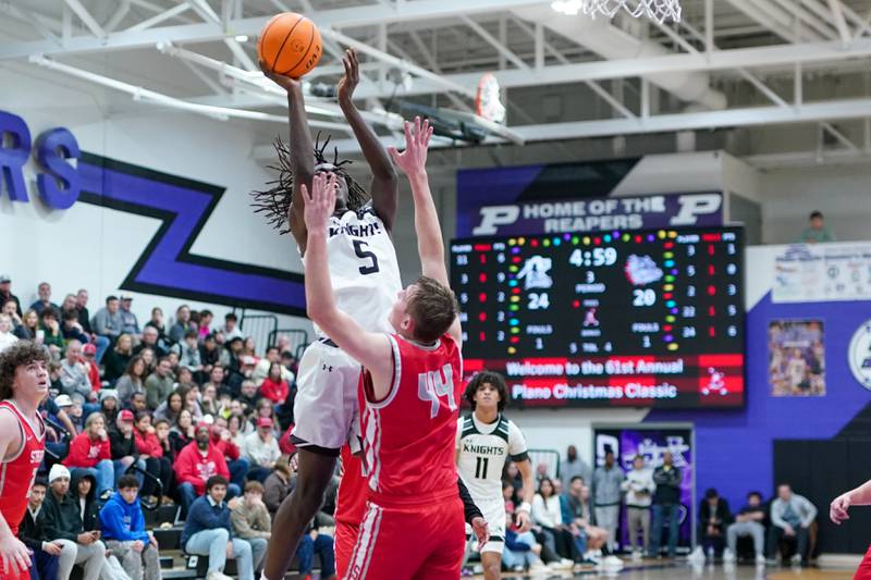 Kaneland's Freddy Hassan (5) shoots the ball in the post over Streator's Nolan Lukach (44) during a semi-final basketball game in the 61st annual Plano Christmas Classic at Plano High School on Friday, December 27, 2024.