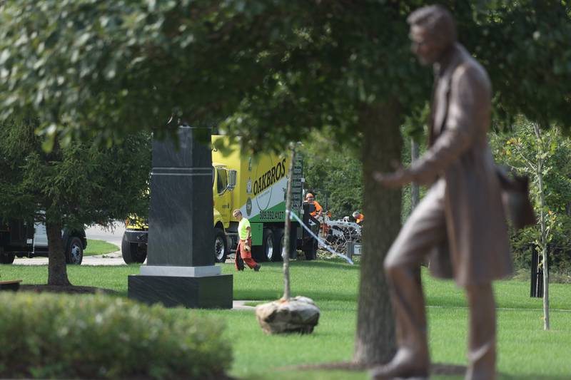 Volunteers from Oakbros Tree Care & Removal chop up dead tree branches and brush at the Abraham Lincoln National Cemetery on Wednesday, Sept. 20, in Elwood.