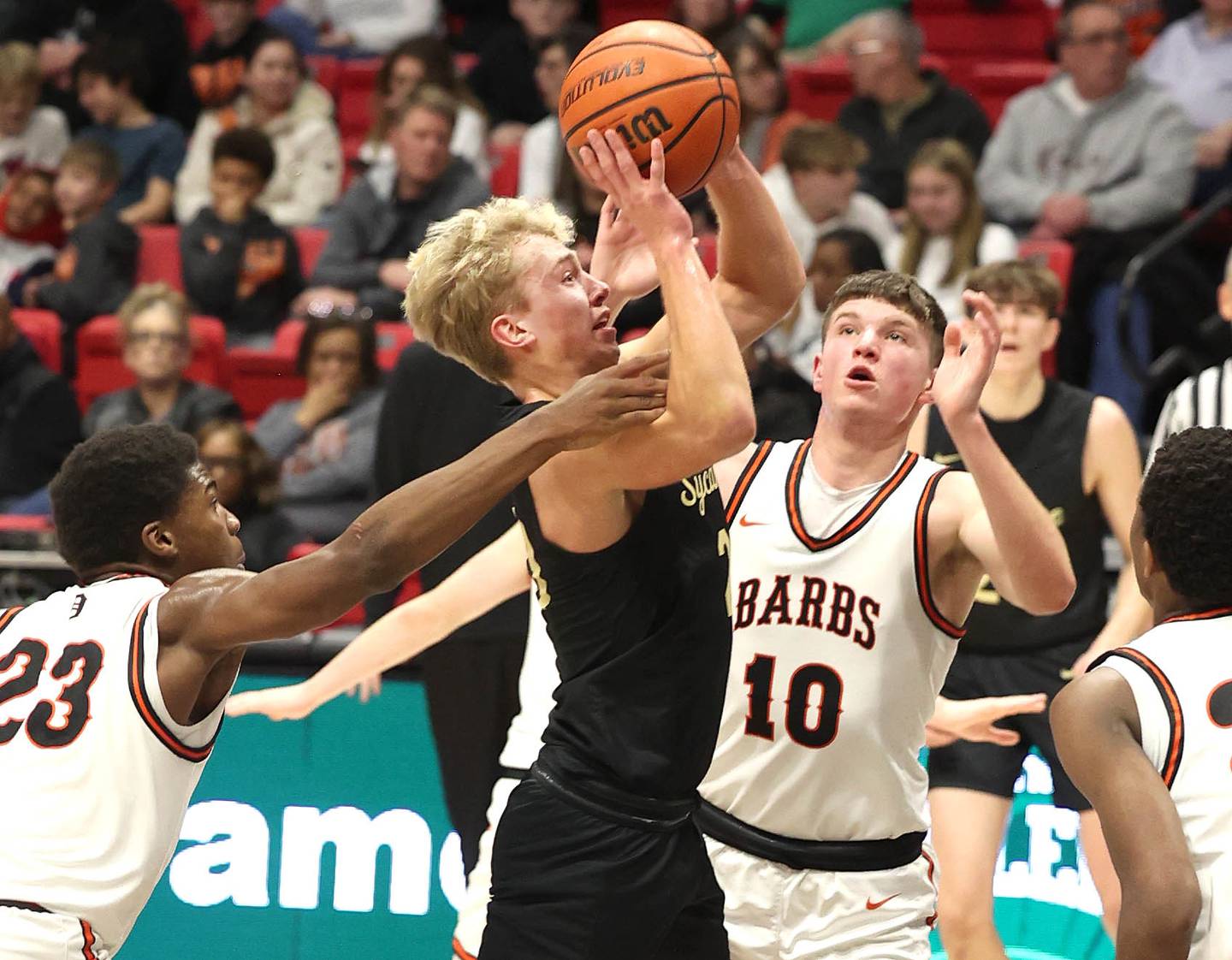 Sycamore's Carter York goes to the basket between two DeKalb defenders Friday, Jan. 26, 2024, during the FNBO Challenge in the Convocation Center at Northern Illinois University.
