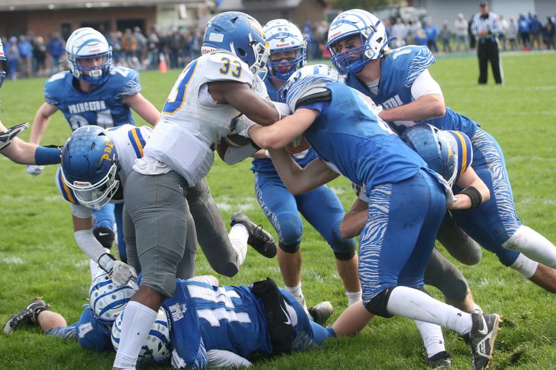 Paxton-Buckley-Loda's Robert Boyd-Ments (33) is brought down by Princeton defenders Common Green, Noah Laporte and Arthur Burden in the Class 3A playoff game on Saturday, Oct. 28, 2023 at Bryant Field.