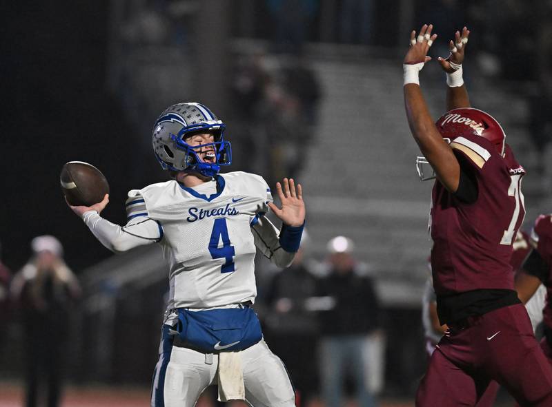 Woodstock's Caden Thompson (4) looks to throw a under pressure during the class 4A first round playoff game against Morris on Friday, OCT. 31, 2025, at Morris.