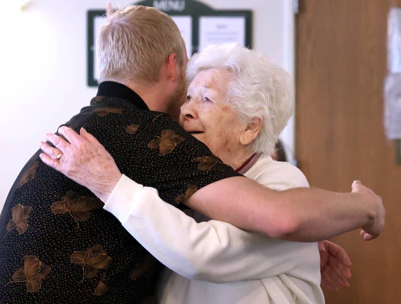 Heritage Woods of DeKalb resident Phyllis Fawcett, gets a hug from a member of the staff during her surprise 100th birthday party Thursday, March 21, 2024, at Heritage Woods.