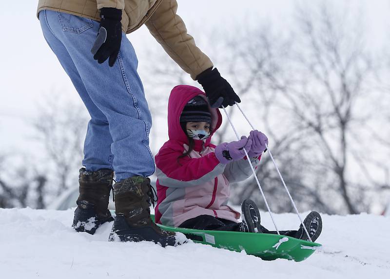 Mike Kirchner helps his granddaughter, Abby, 9, of Wonder Lake sled at Veteran Acres Park Monday afternoon, Jan. 24, 2022, after McHenry County received a fresh snowfall.