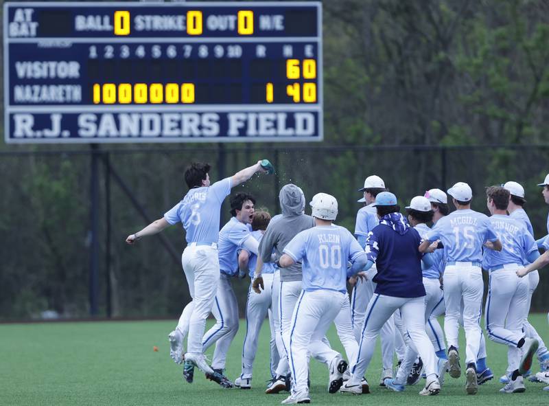 Nazareth celebrates Drew Hyland's (13) walk-off game-winning hit against Joliet Catholic during the varsity baseball game on Wednesday, April 20, 2025 between Nazareth and Joliet Catholic academies in La Grange Park.