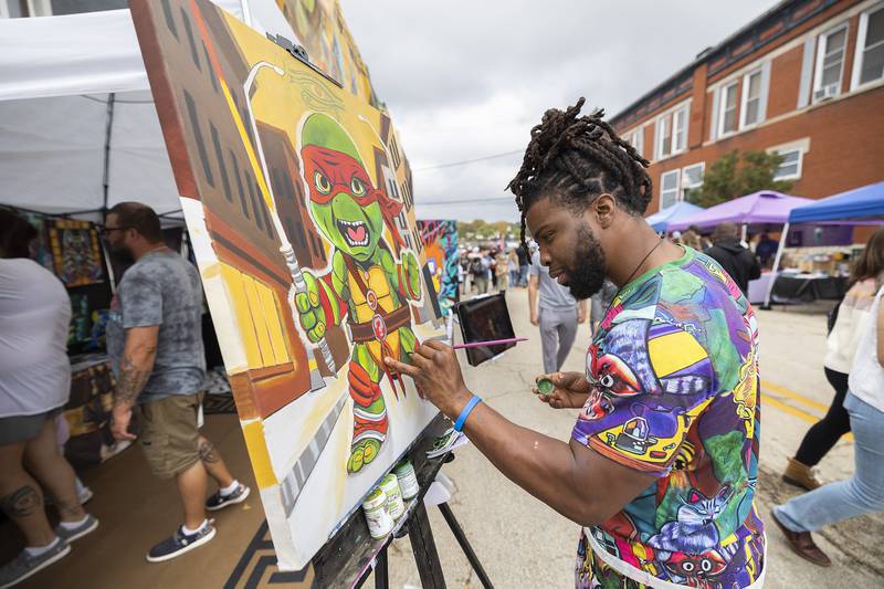 Sterling artist Pharaoh Kemet of Kemetic Creations works on a piece Saturday, Oct. 18, 2025, at Dixon’s Scarecrow Fest. The artist was live painting works and selling others at the popular festival.