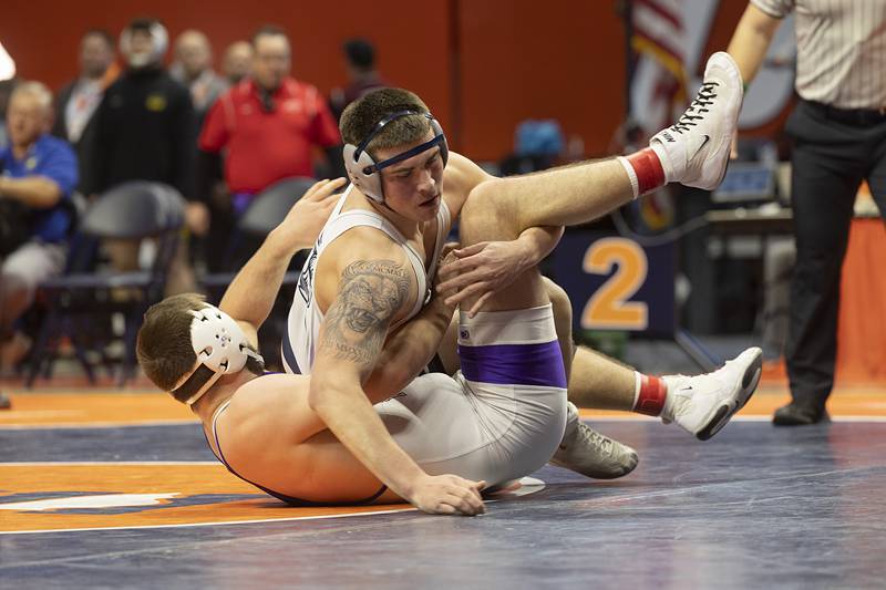 IC Catholic’s Michael Calcagno grabs the leg of Rochelle’s Kaiden Morris in the 2A 215 pound championship match Saturday, Feb. 17, 2024 at the IHSA state wrestling finals at the State Farm Center in Champaign.