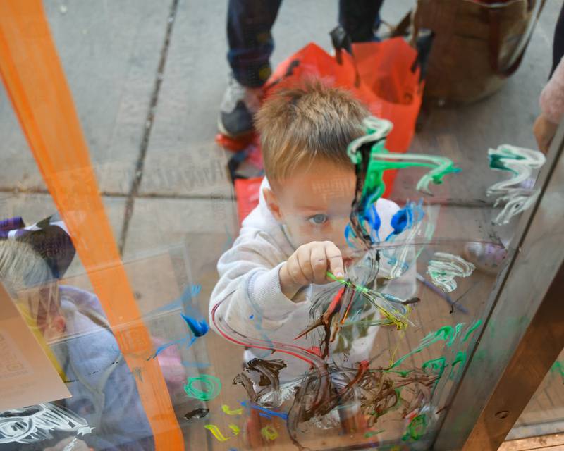 Lucas Orf, 2 years old, of Downers Grove paints a window during the Halloween Window painting event held Downtown Downers Grove on Saturday Oct. 21, 2023.