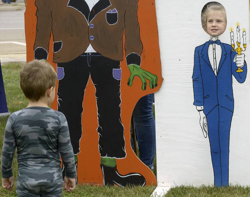 Hudson Hill looks at his cousin Emersyn Hill peeking out of a Halloween cutout Saturday, Sept. 28, 2024, at the Jordan block during the annual Scarecrow Fest in Ottawa.