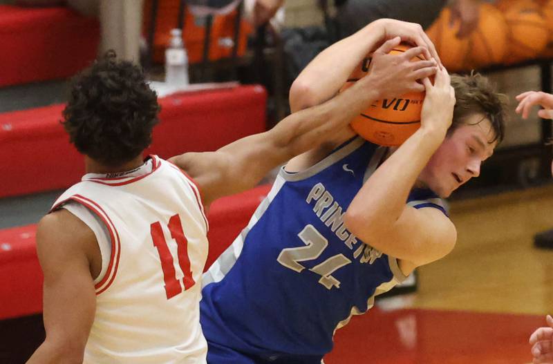 Princeton's Ryan Jagers comes down with the ball over Ottawa's Hezekiah Joachim during the Dean Riley Shootin' The Rock Thanksgiving Tournament on Monday Nov. 24, 2025 in Kingman Gymnasium at Ottawa High School.