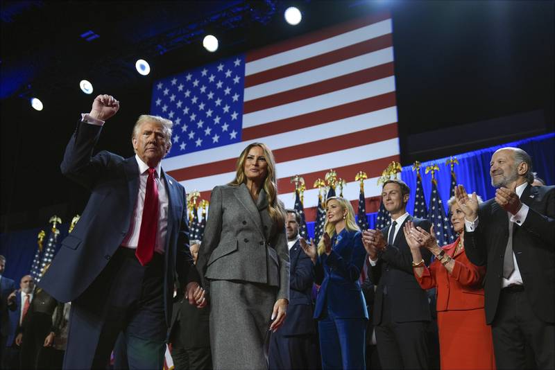 Republican presidential nominee former President Donald Trump gestures as he walks with former first lady Melania Trump at an election night watch party at the Palm Beach Convention Center, Wednesday, Nov. 6, 2024, in West Palm Beach, Fla. (AP Photo/Evan Vucci)