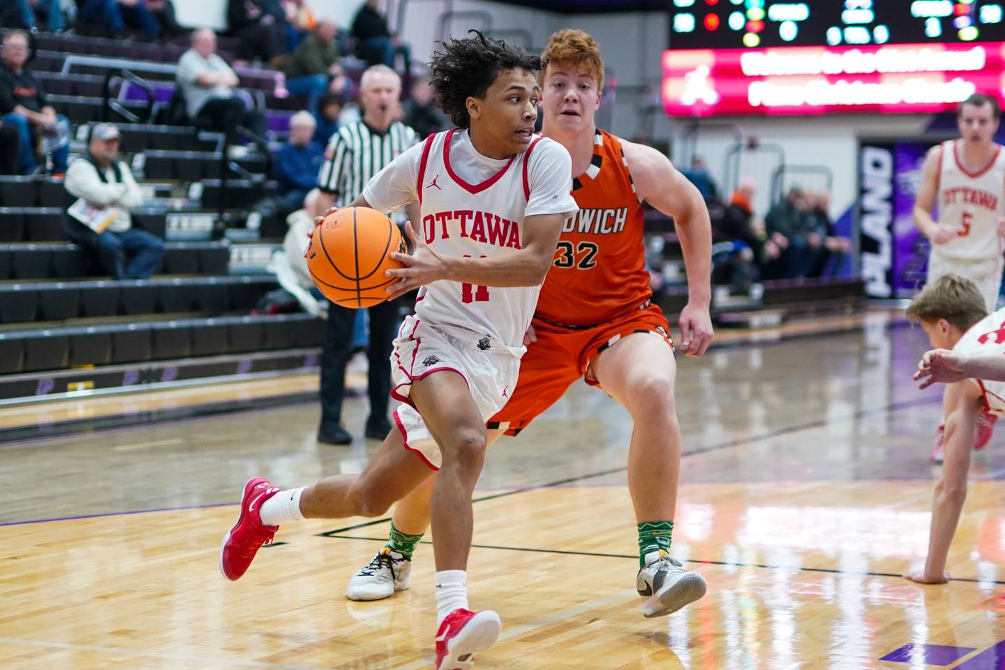 Ottawa’s Khezekiah Joachim (11) drives the baseline against Sandwich’s Quinn Rome (32) during a basketball game in the opening round of the 61st annual Plano Christmas Classic at Plano High School on Monday, December 23, 2024.