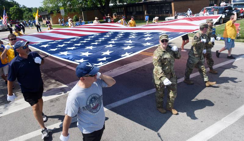 Joe Lewnard/jlewnard@dailyherald.com
A large American flag is carried along the route of the Algonquin Founders Day parade Saturday.