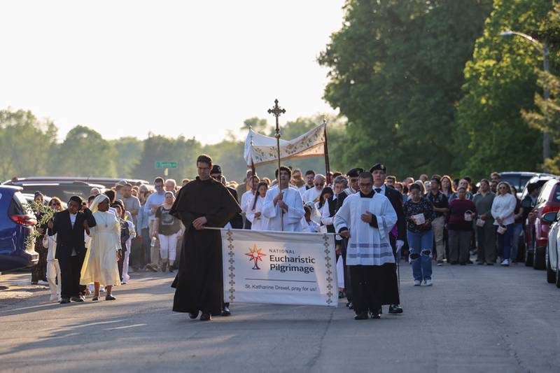 Hundreds walk in the procession as the Eucharist in the monstrance is carried around St. John Paul II parish grounds during the National Eucharistic Pilgrimage stop in Kankakee on Sunday, May 18, 2025.