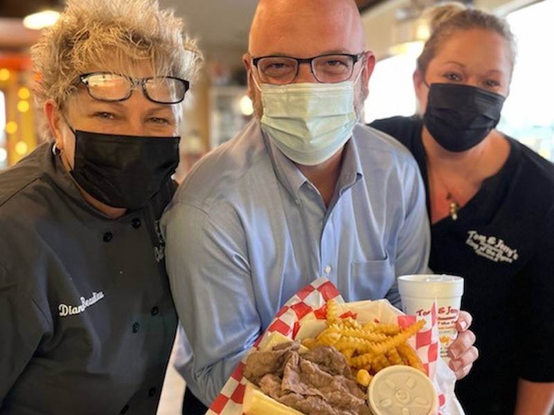 State Rep. Jeff Keicher, R-Sycamore, (middle) shows off an Italian beef meal with Tom and Jerry’s of Sycamore owner Diann Beaulieu and employee Sarah Meyer