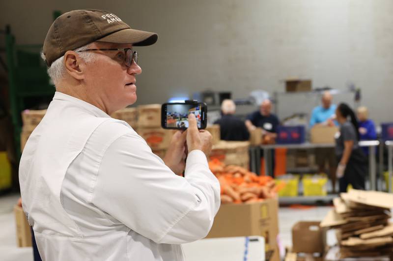 Feeding America supporter Brian Christner films volunteers for his social media accounts at the South Suburban Center Food Bank in Joliet, during a stop from his walk across America. Brian started his fundraising journey in Delaware on February 19th and expects to finish outside San Francisco in December.