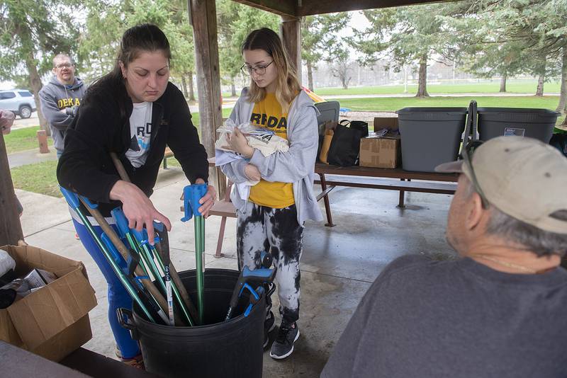 Julie Bogusiewicz, left, and Fantasia Ward of Girl Scout Troop 1471 pick up some arm extension grabbers Saturday before they head off to pick up trash for the Rock River Development Authority.