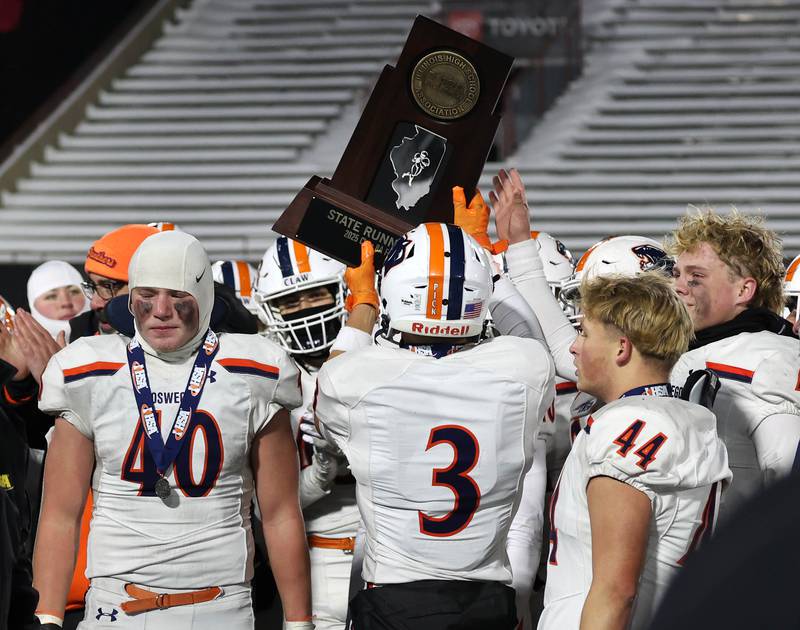 Oswego players hoist the state runner up trophy Wednesday, Dec. 3, 2025, after their loss to Mount Carmel in the IHSA Class 8A state chamionship game in Huskie Stadium at Northern Illinois University in DeKalb.