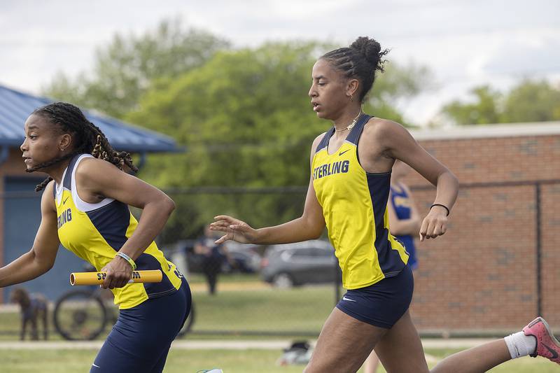 Sterling’s Ta’ah Liberty takes the baton from Alivia Gibson in the 4x100 Sectional race Wednesday, May 14, 2025, in Sterling.