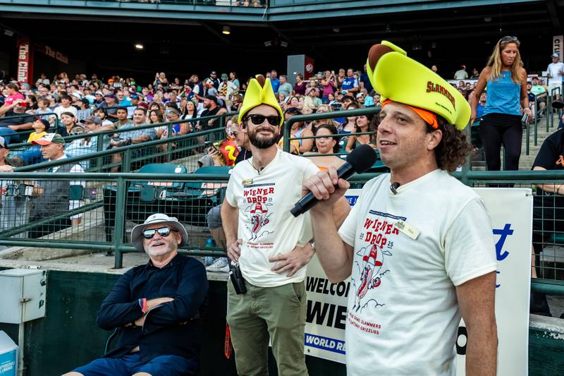 Joliet Slammers co-owners Bill Murray and  Night Train Veeck enjoy the commentary from Max Ganet, the evening's emcee, before the Wiener Drop World Record Attempt at Duly Heath and Care Field on July 22, 2025.