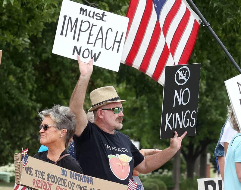 Protesters hold signs saying “Impeach,” and “No Kings,” Saturday, July 4, 2025, at the corner of Main and State Streets in front of the DeKalb County Courthouse in Sycamore for a "No Kings" rally to voice their displeasure with President Donald Trump.