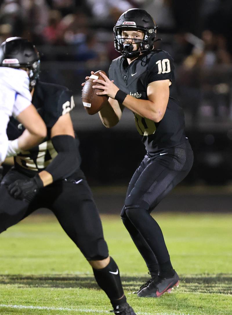 Sycamore's Burke Gautcher looks for a receiver in the Woodstock secondary during their game Friday, Sept. 8, 2023, at Sycamore High School.