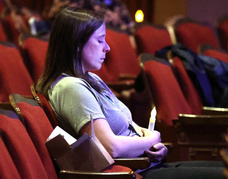 Kesley Gettle, from Safe Passage, takes a moment to quietly reflect as the candles are turned on during the Safe Passage Candlelight Vigil and Survivor Speak Out Monday, Oct. 6, 2025, at the Egyptian Theatre in DeKalb.