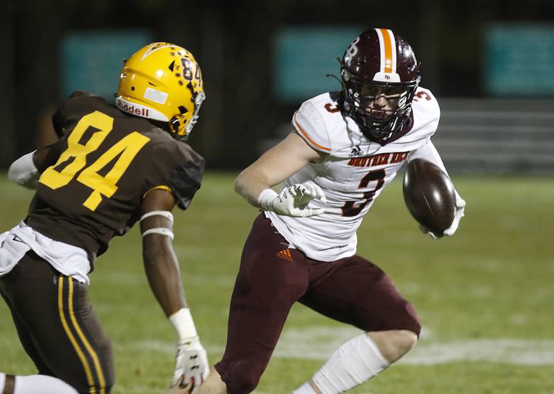 Brother Rice's Martin O’Keeffe, right, tries the avoid the pursuit of Jacobs' T.O. Boddie during a IHSA Class 7A first round playoff football game Friday, Oct. 28, 2022, between Jacobs and Brother Rice at Jacobs High School in Algonquin.