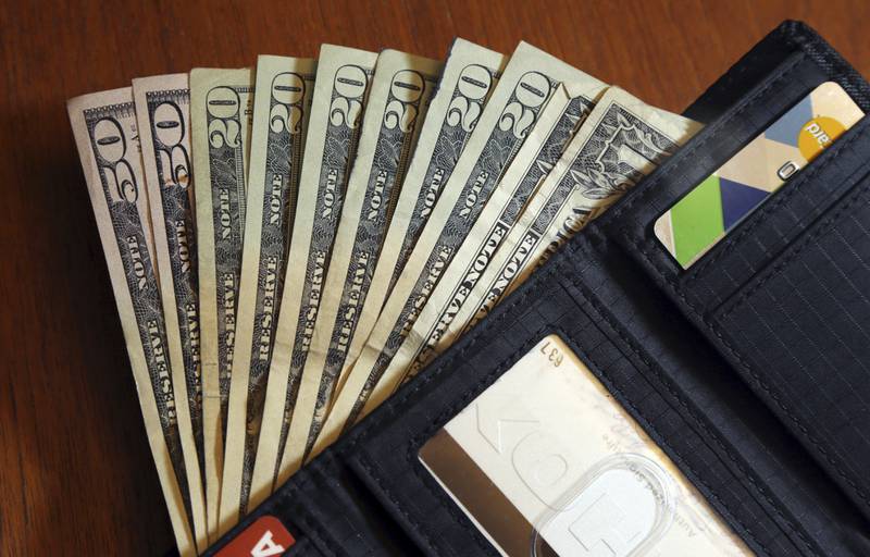 FILE - Cash is fanned out from a wallet in North Andover, Mass., June 15, 2018.