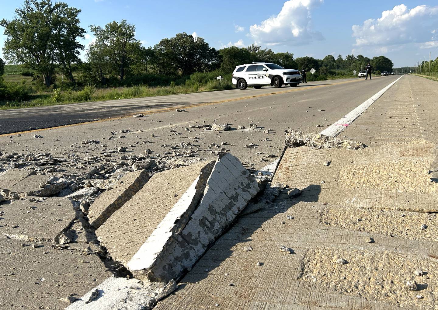 A Byron squad car blocks traffic on Illinois Route 2 on Wednesday evening, July 2, 2025 after the pavement buckled just north of the intersection with Town Hall Road, south of Byron. On Tuesday evening, the road buckled at the location and at another a few miles south near the Silver Ridge Golf Course. Traffic was again detoured off the state highway Wednesday as Illinois Department of Transportation crews patched the blowout.