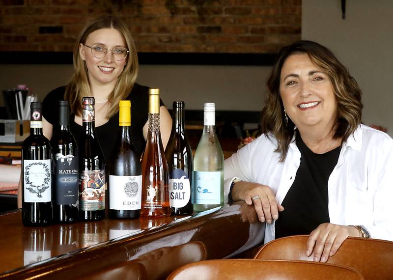 Liz Bednarczyk and her daughter, Rachel, with some of the wine that they will carry in their new wine shop, Off the Vine, on Friday, June 30, 2023.