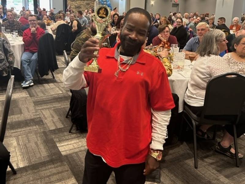 Ontario "Mooka" Allen holds the GOAT [Greatest of All Time] Award he received Wednesday at Self Help Enterprises' Client Awards Banquet in Rock Falls.