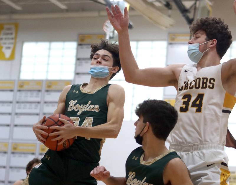 Jacobs’ Grant Stec, right, and Boylan’s Tyler Hood, left,  go up for a rebound against during boys varsity basketball against Rockford Boylan at Algonquin Saturday afternoon.