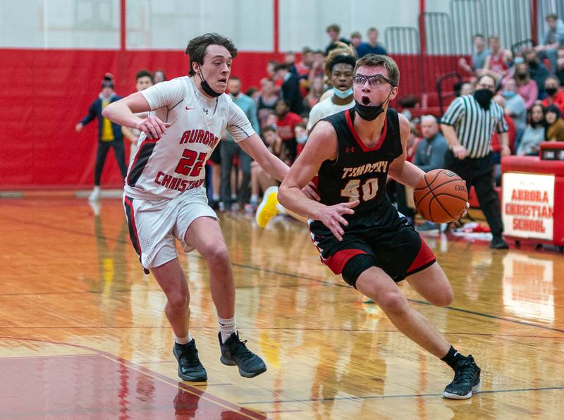 Timothy Christian's Ben VanderWal (40) drives to the basket against Aurora Christian's Trey Beebe (22) during a basketball game at Aurora Christian High School on Tuesday, Jan 25, 2022.