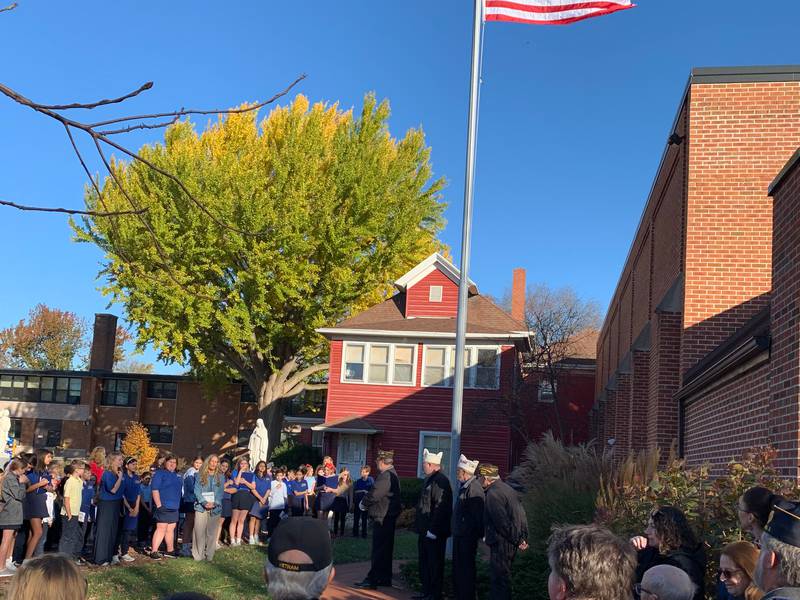 Students and residents gather around the flagpole at Immaculate Conception School in Morris for its rededication.