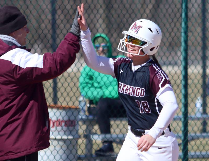 Marengo’s  AJ Pollnow is greeted by Head Coach Dwain Nance after belting a grand slam against North Boone in varsity softball at Marengo High School in Marengo on Saturday, March 22, 2025.